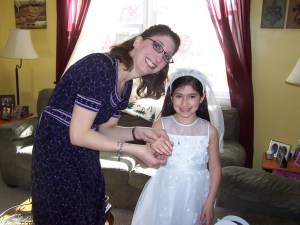 Giving Alexandra her special First Communion bracelet, a tradition we started with Caroline.